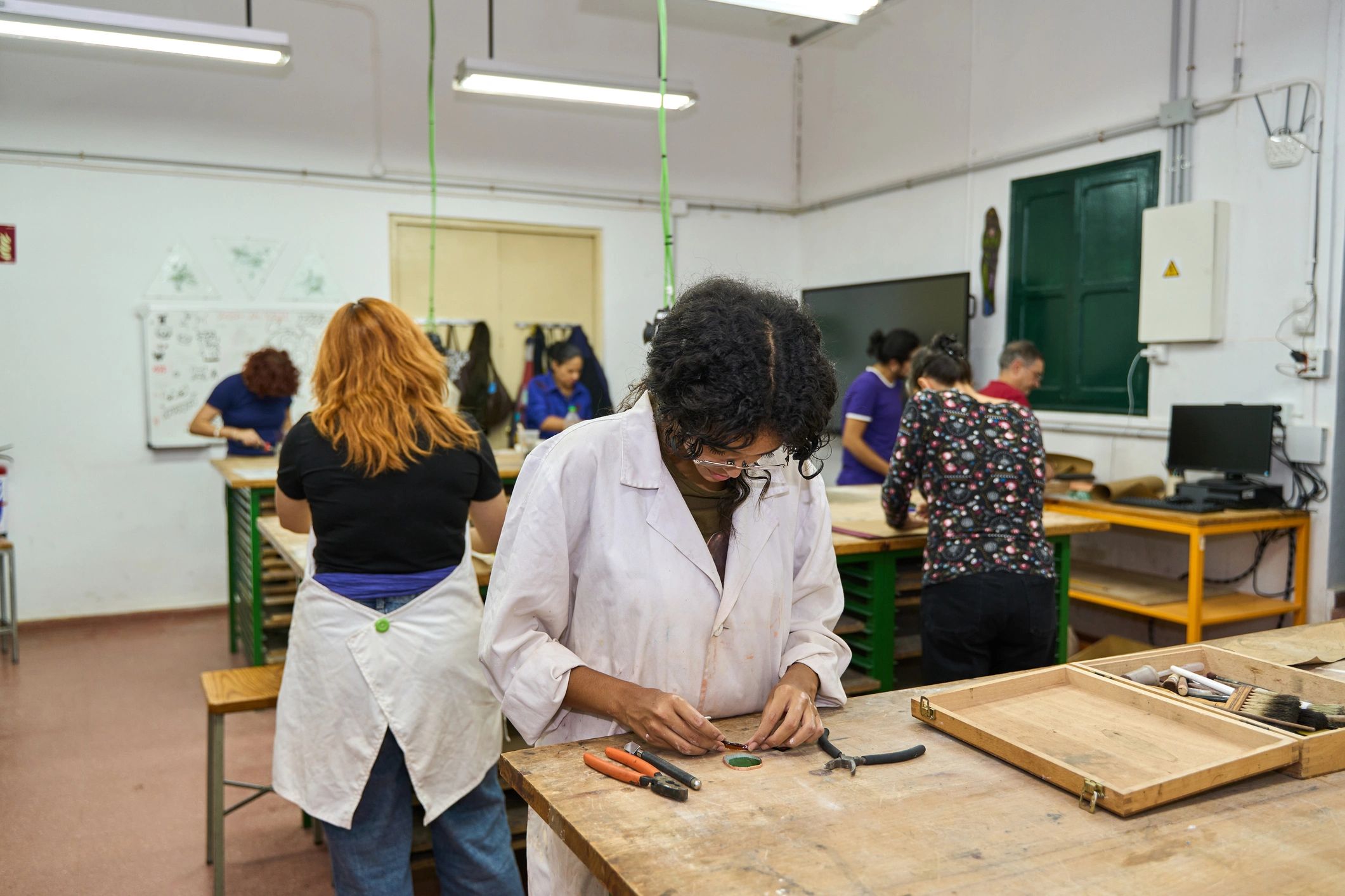 Adults learning practical craft skills in a workshop